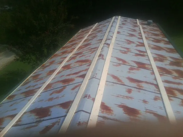 Rusted metal roof panels with new wood purlins before replacement — Storm Damage Roof Repair in Kilgore by Roofing Brothers